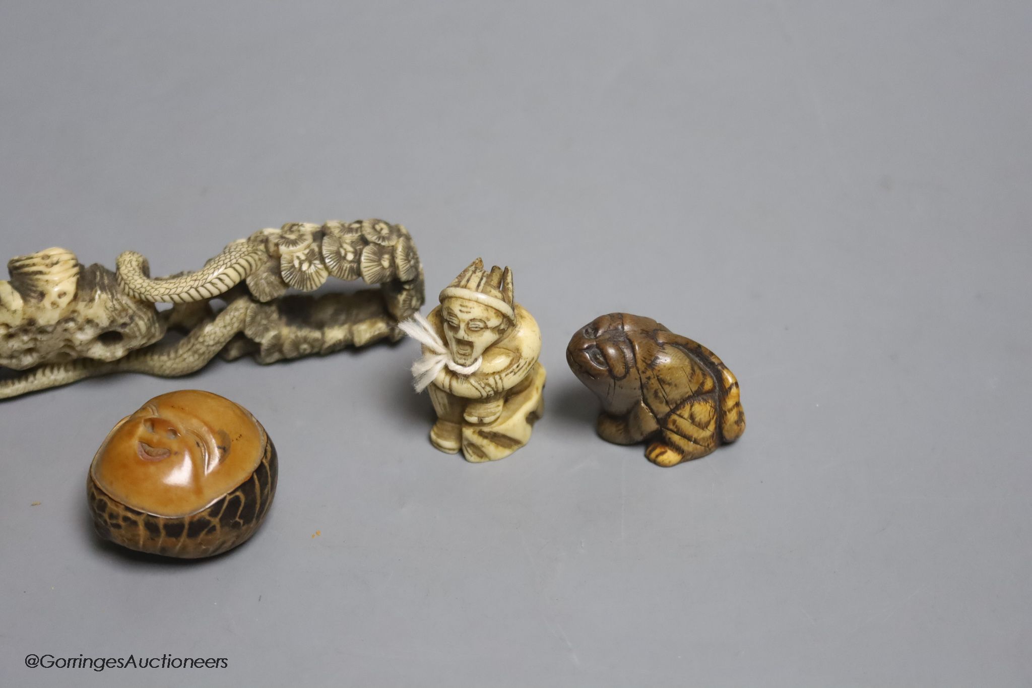 Two Japanese stag antler netsuke, a stained ivory tiger netsuke, a walrus ivory carving and a nut mask netsuke